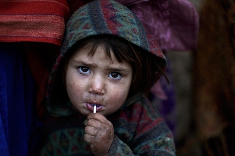 Một bé gái người Afghanistan thích thú khi được tặng chiếc kẹo mút.