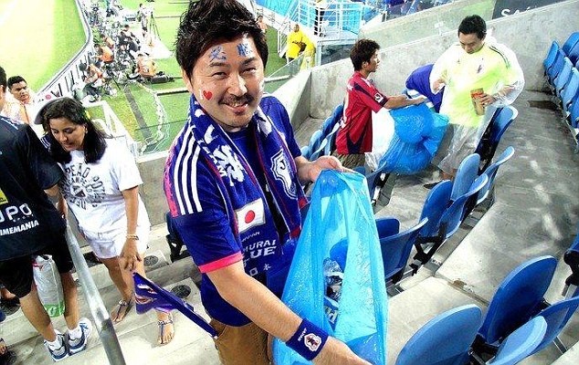 Cổ động viên Nhật Bản dọn rác ở sân vận động sau khi xem. Ảnh: Daily Mail.