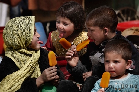 Một bé gái người Afghanistan thích thú khi được tặng chiếc kẹo mút.