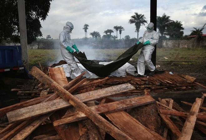 Các nhân viên y tế Liberia đưa túi đựng thi thể nạn nhân nhiễm Ebola lên một giàn thiêu tại Marshall. Ảnh: Getty 